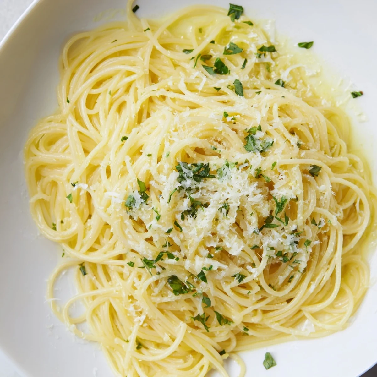 A vibrant close-up showing steaming Lemon Capellini, bursting with fresh basil and zesty lemon flavor.