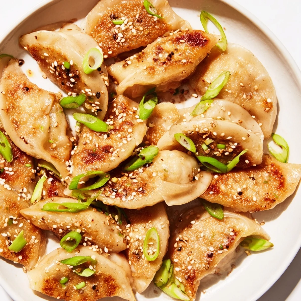 Crispy air fryer frozen dumplings glazed with sesame oil, garnished with fresh green onions.