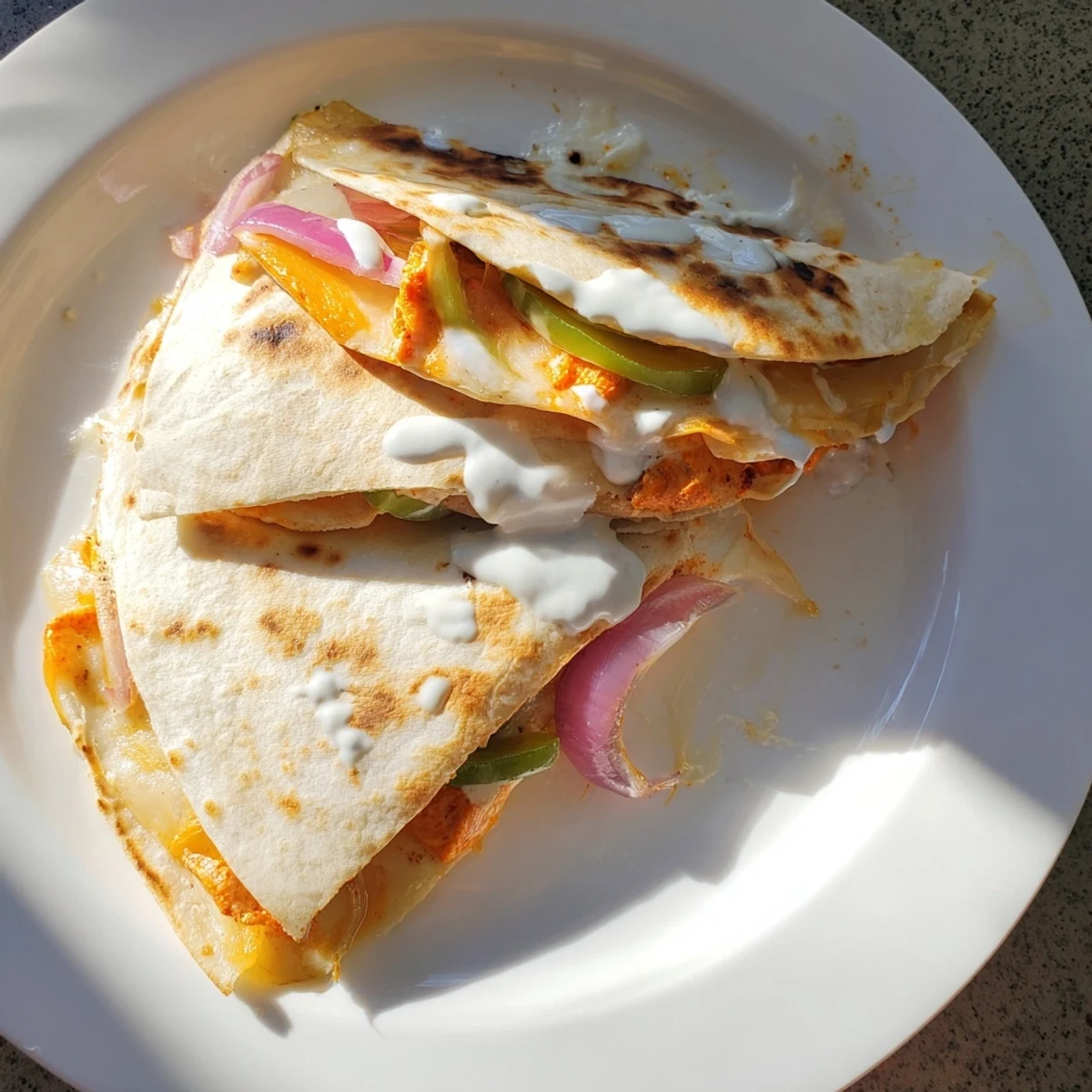 Freshly made Tandoori Chicken Quesadilla, sliced and ready to serve with creamy yogurt sauce.