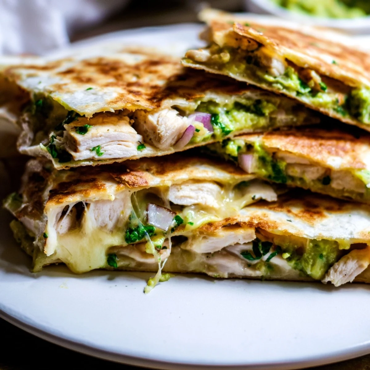 Warm, freshly grilled Chicken Avocado Quesadilla served on a rustic plate with a dollop of sour cream and a side of salsa.