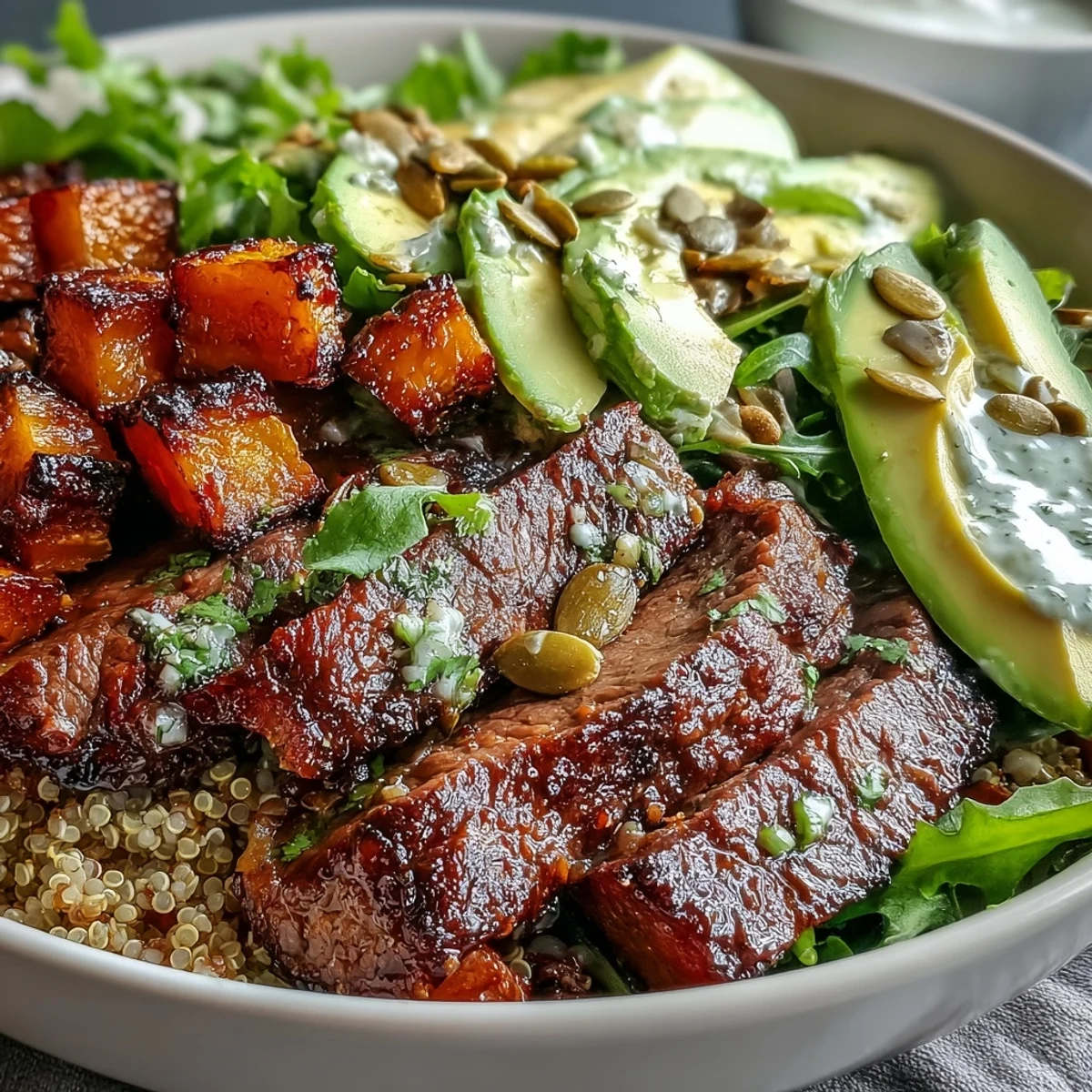 Sizzling flank steak sits beside caramelized squash in a hearty bowl of quinoa and greens, ready for a busy weeknight dinner.