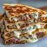 Freshly chopped cilantro and sliced pickles garnish the wedges, ready to be dipped into a creamy, tangy sauce.