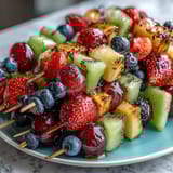 Rainbow Fruit Skewers with Honey Dip, featuring fresh strawberries, pineapple, kiwi, and grapes on skewers, accompanied by a luscious honey-lemon yogurt sauce.  