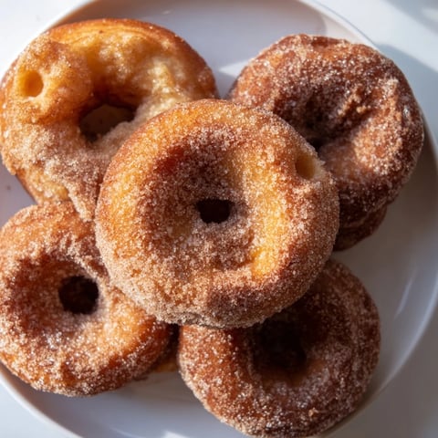 Warm, fluffy 1-Minute Air Fryer Donuts, golden and dusted in sweet cinnamon sugar, ready to eat!