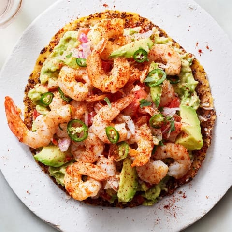 Quick Shrimp and Avocado Tostadas artfully arranged with fresh cilantro and colorful diced tomatoes for a flavorful meal.