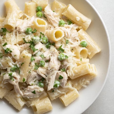 Rich and bubbly Slow Cooker Chicken Alfredo Pasta Bake, perfect for a cozy weeknight dinner; garnished with parsley.