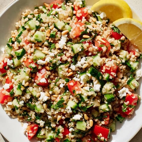 A colorful Tabbouleh Grain Bowl, with bright tomatoes and herbs, perfect for a fresh lunch.
