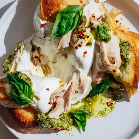 Fresh basil leaves and a drizzle of pesto add flavor to this Italian-inspired Pesto Chicken Burrata Toast.