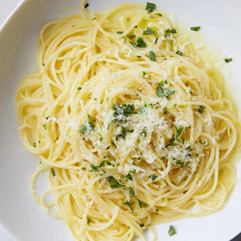A vibrant close-up showing steaming Lemon Capellini, bursting with fresh basil and zesty lemon flavor.