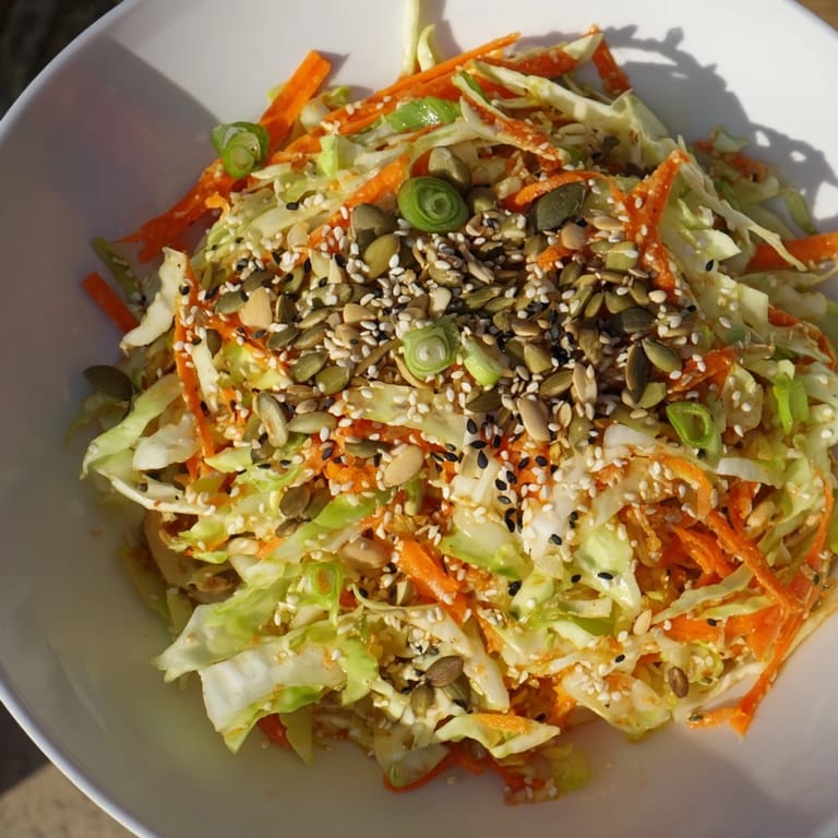 A bowl of homemade Cabbage-Core Slaw Salad, with a drizzle of sesame dressing, perfect for a refreshing vegan lunch.