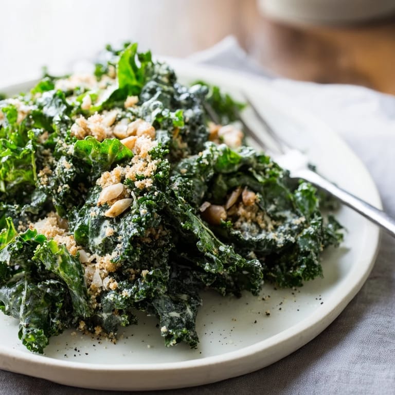 Visual guide for the Garlic Parmesan Kale Salad: tender dark greens coated in creamy dressing, garnished with shaved Parmesan and crisp breadcrumbs for extra texture.