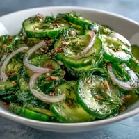 Bright, chilled Refreshing Crunchy Cucumber Salad with thinly sliced cucumbers, red onions, and dill in a tangy vinegar dressing. 