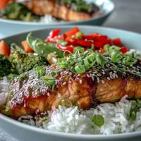 Vibrant Teriyaki Salmon Bowl with glossy glazed fillet atop fluffy rice and colorful, crisp stir-fried vegetables.  