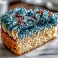 A stunning teal and gold geode cake slice reveals shimmering crystal layers inside, perfect for graduation celebrations.  